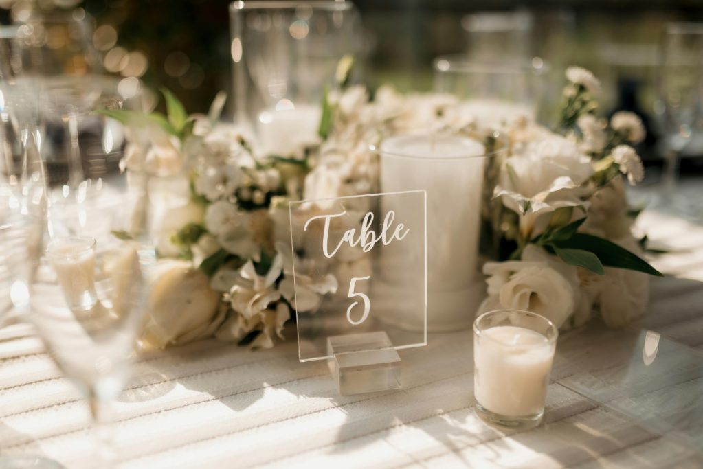 Elegant wedding table setting with white flowers and a centerpiece labeled "Table 5."
